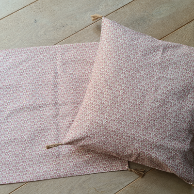 Housse de coussin avec pompons rose